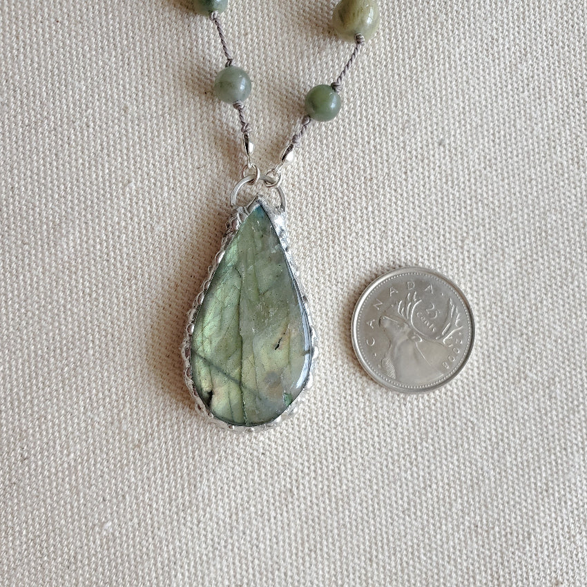 Labradorite teardrop focal beside a quarter