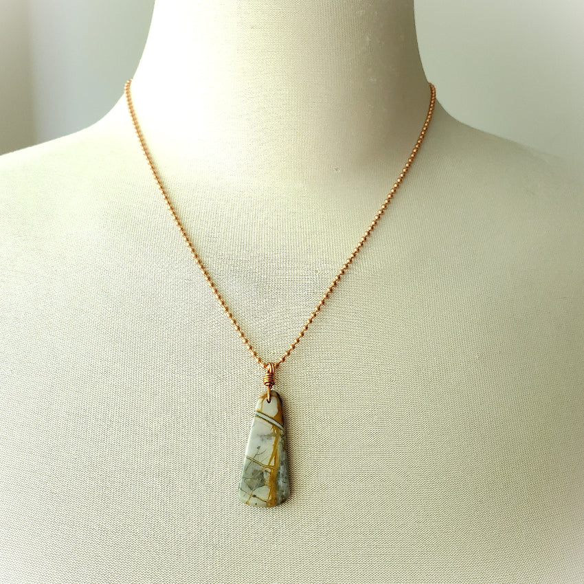 Necklace with a pendant on a mannequin against a neutral background