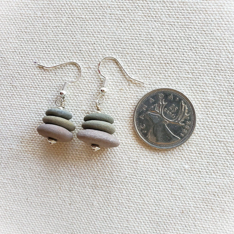 Beach rock stack earrings beside a quarter