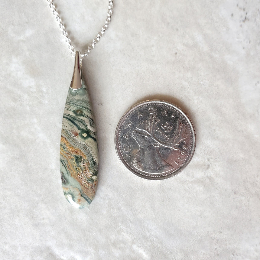 Ocean Jasper teardrop pendant necklace beside a quarter