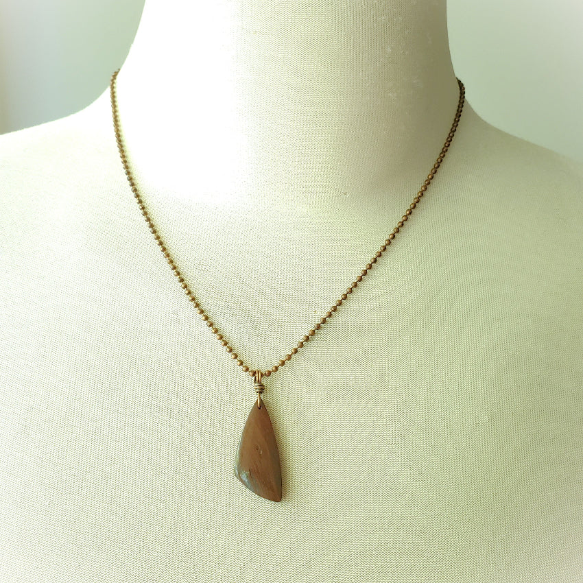 Necklace with a pendant on a mannequin against a neutral background