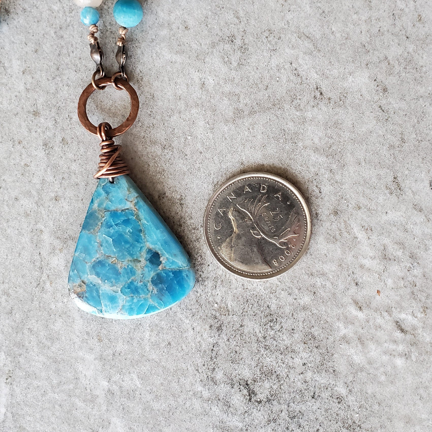 Blue Apatite and Sunstone Knotted necklace focal beside a quarter