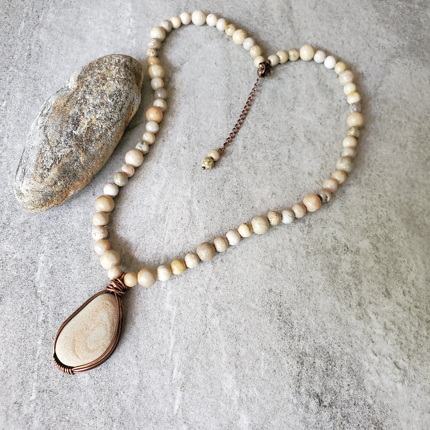 Beach rock focal stone with Fossil Coral necklace on tile