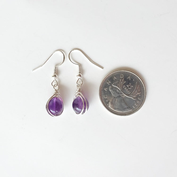 Amethyst herringbone wrap silver earrings beside a quarter