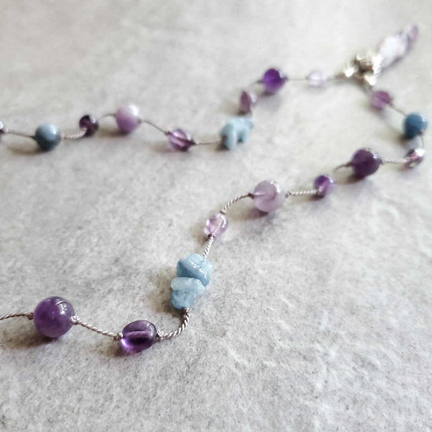 detail of an Amethyst and Aquamarine knotted necklace
