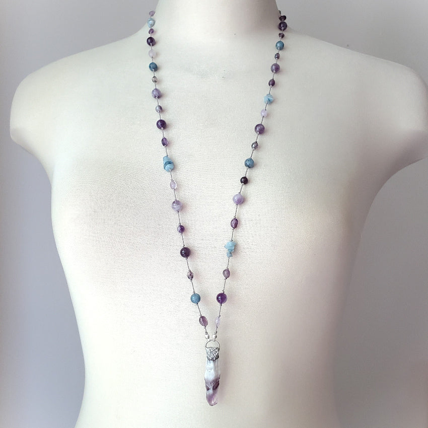 Beaded necklace on a mannequin with a plain background