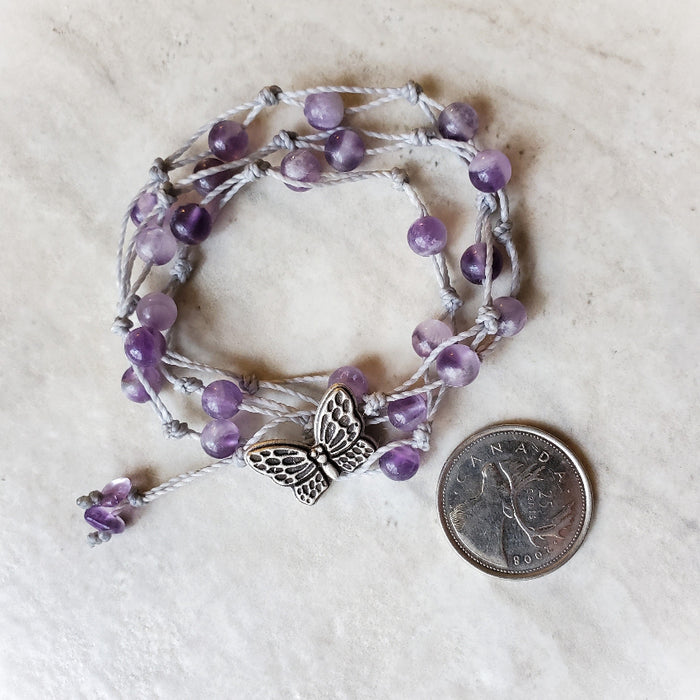 Amethyst 3 wrap bracelet beside a quarter