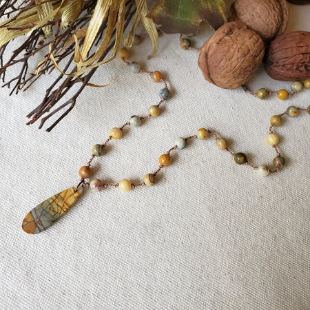 knotted Crazy Lace Agate necklace with Picasso Jasper focal on linen