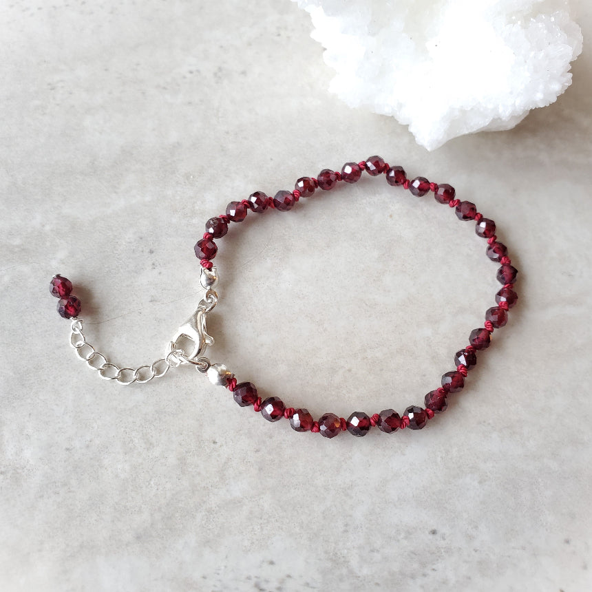 Garnet knotted bracelet on tile
