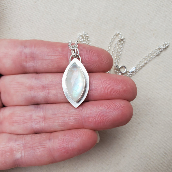 Rainbow moonstone marquise bezel set pendant in hand