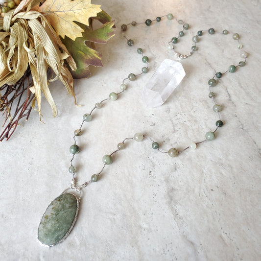 Beaded gemstone necklace on tile