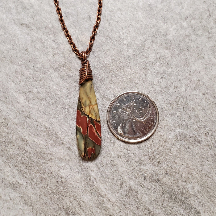 Picasso Jasper teardrop pendant necklace beside a quarter