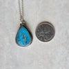 Arizona turquoise silversmith necklace beside a quarter