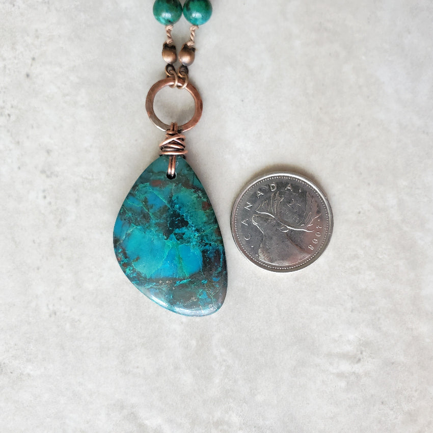 Azurite & Chrysocolla silk knotted necklace beside a quarter