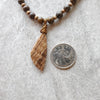 Bronzite and Aragonite chunky necklace beside a quarter