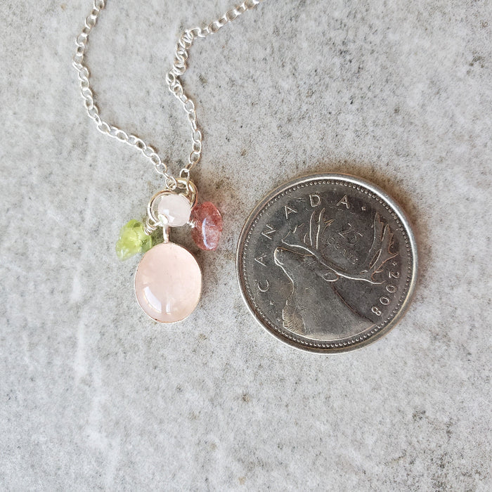 Rose Quartz Cluster Dangle Pendant necklace beside a quarter