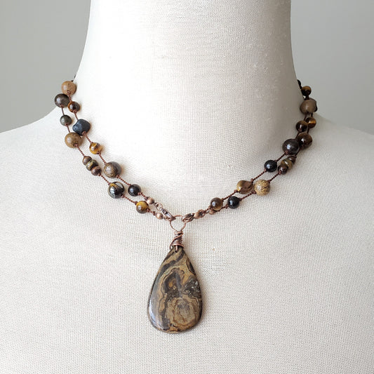 Necklace with a teardrop pendant on a mannequin bust against a plain background