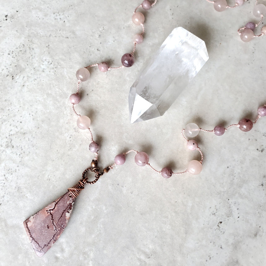 Necklace with pink beads on a light gray surface