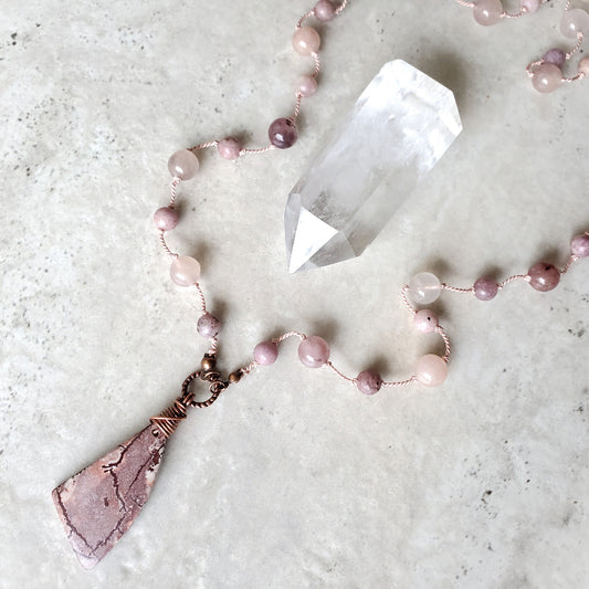 Necklace with pink beads on a light gray surface