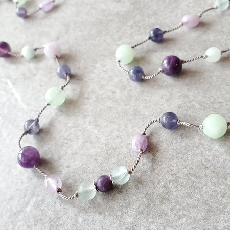 Purple and Green gemstone knotted necklace on tile