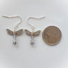 Faceted Fluorite dragonfly earrings beside a quarter