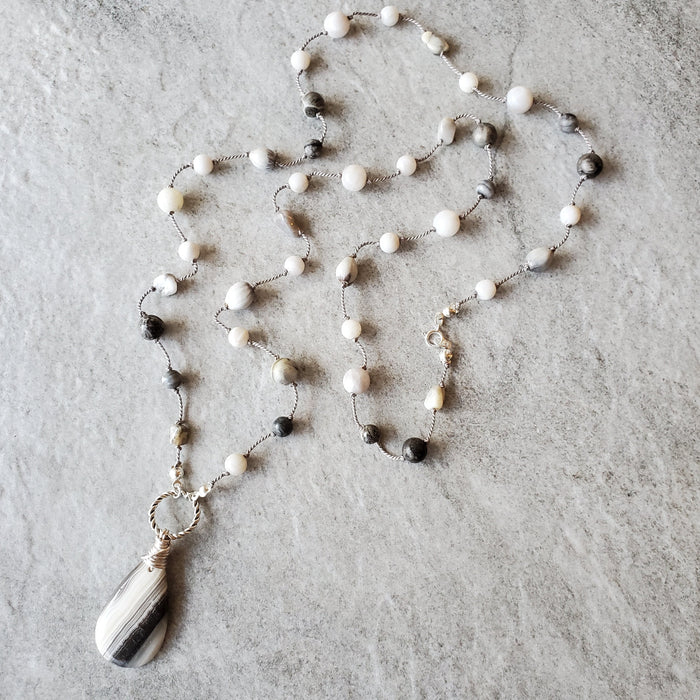 long Zebra Calcite hand knotted beaded necklace on tile