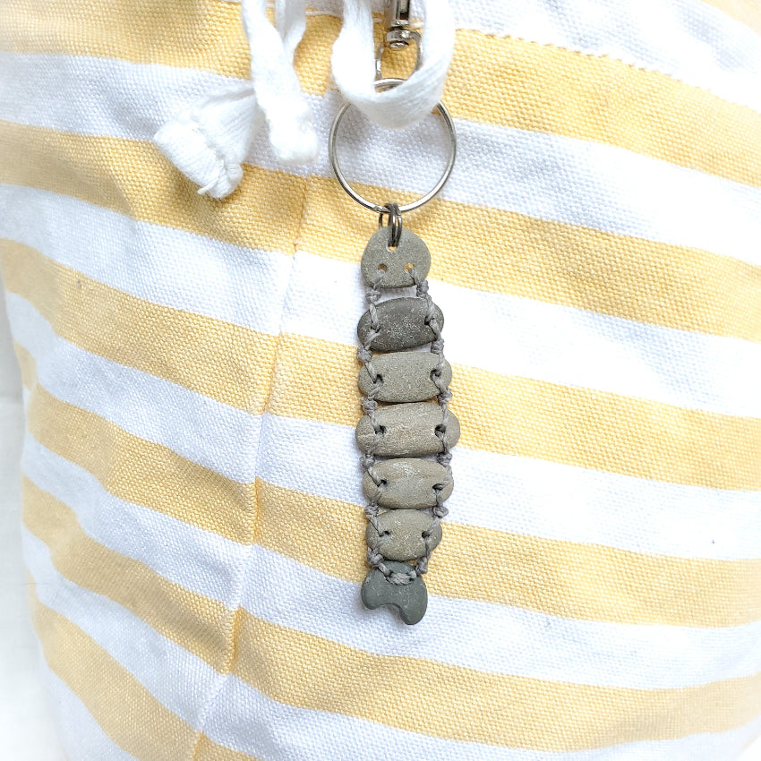 Keychain with a fish design on a yellow and white striped fabric background