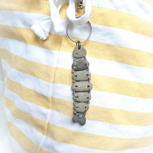 Keychain with a fish design on a yellow and white striped fabric background