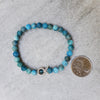 frosted 6mm Blue Apatite bracelet beside a quarter
