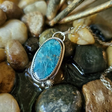 Blue Apatite oval silversmith pendant on rocks