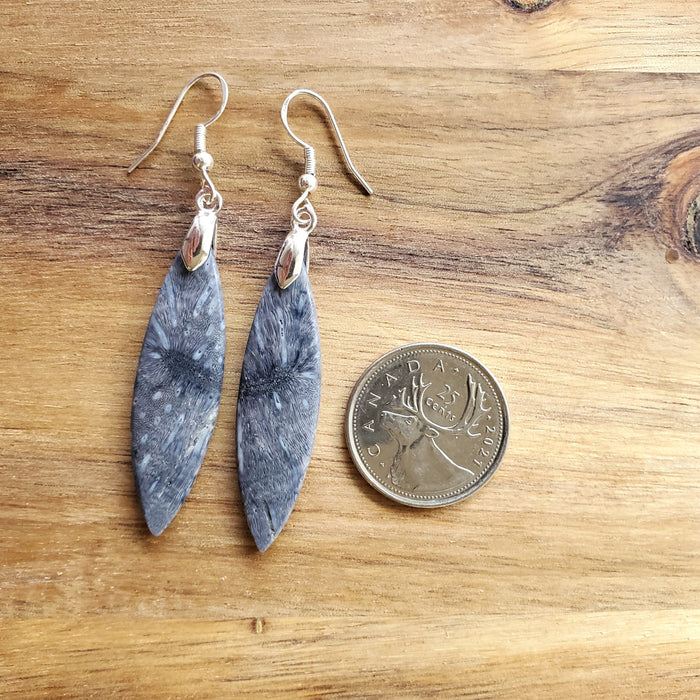 Blue coral marquise earrings beside a quarter
