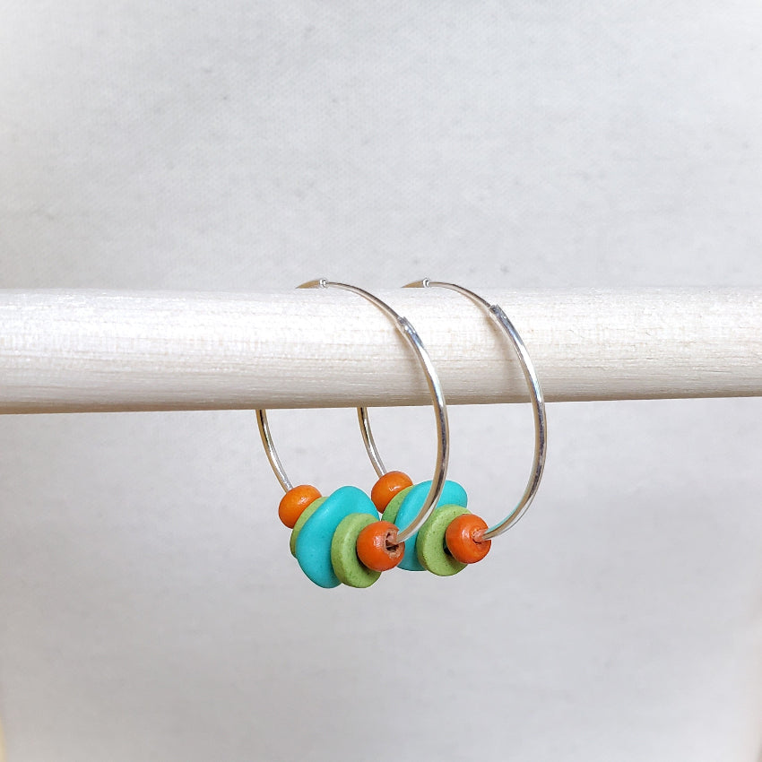 Hoop earrings with colorful beads on a white background