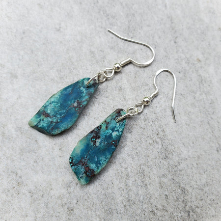 Freeform Chrysocolla nuggets hung on sterling silver ear wires on tile