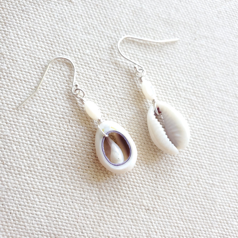 Shell earrings on a textured white surface