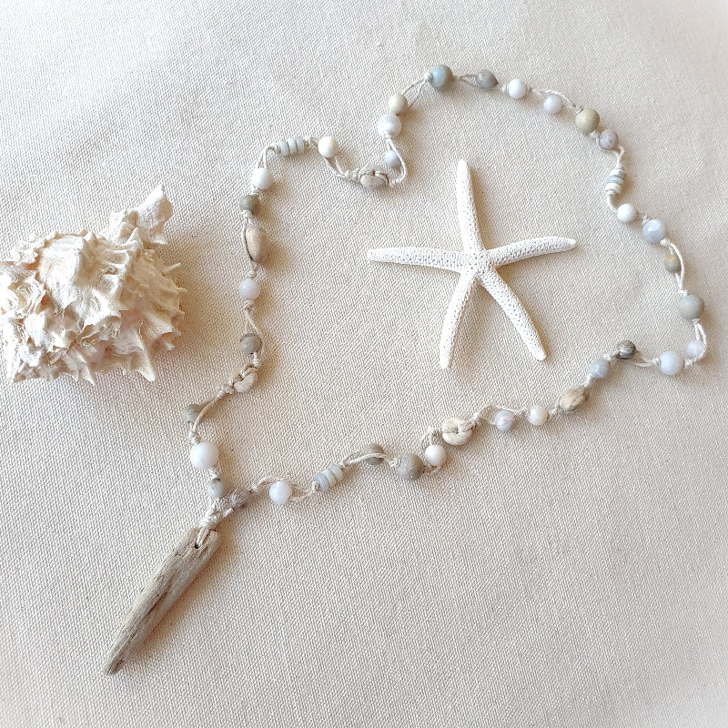 Necklace with shell and starfish decorations on a beige background
