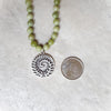 Canadian Jade Knotted necklace with fern focal beside a quarter