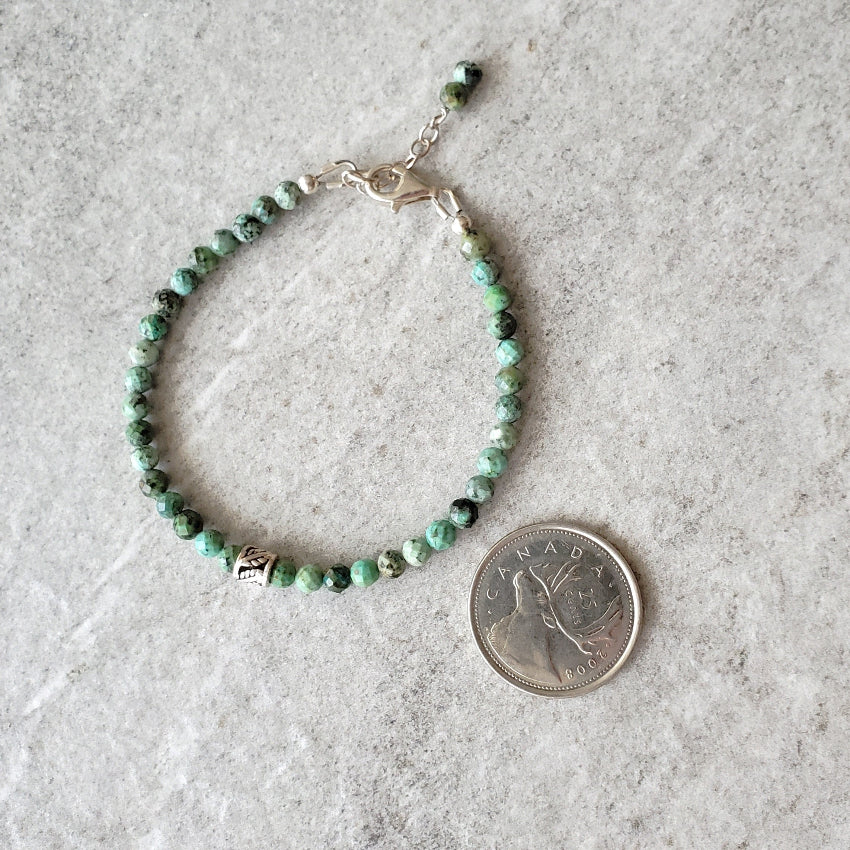 Faceted African Turquoise bracelet beside a quarter