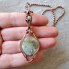 Moss Agate  wire wrapped pendant in hand