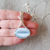 Blue Opal wire wrapped silver pendant in hand