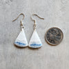 Blue Scheelite gemstone earrings beside a quarter