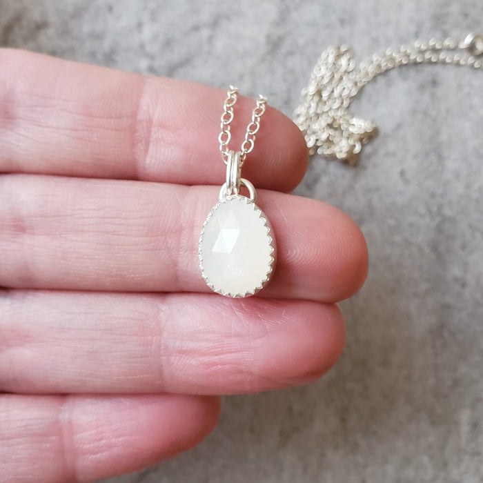 faceted white moonstone pendant in hand
