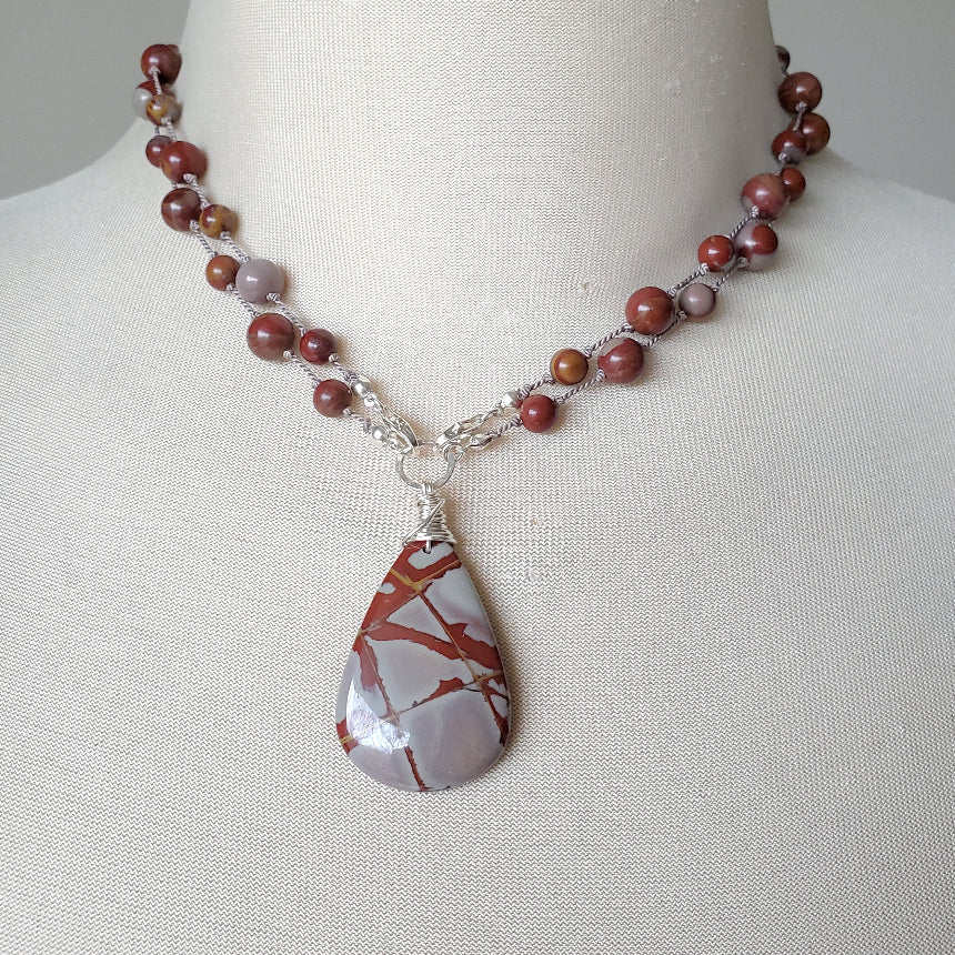 Necklace with a teardrop-shaped pendant on a mannequin bust.