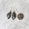 Honey dendrite freeform earrings beside a quarter