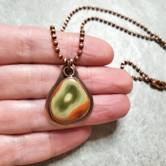 Freeform Imperial Jasper copper metalsmith pendant in hand