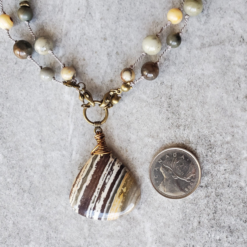 Zebra Jasper Multi Gemstone Knotted Necklace beside a quarter