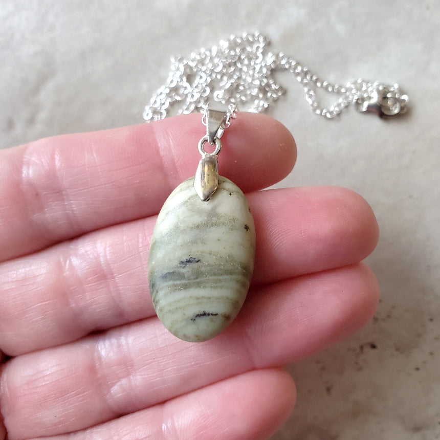 Serpentine oval pendant necklace in hand