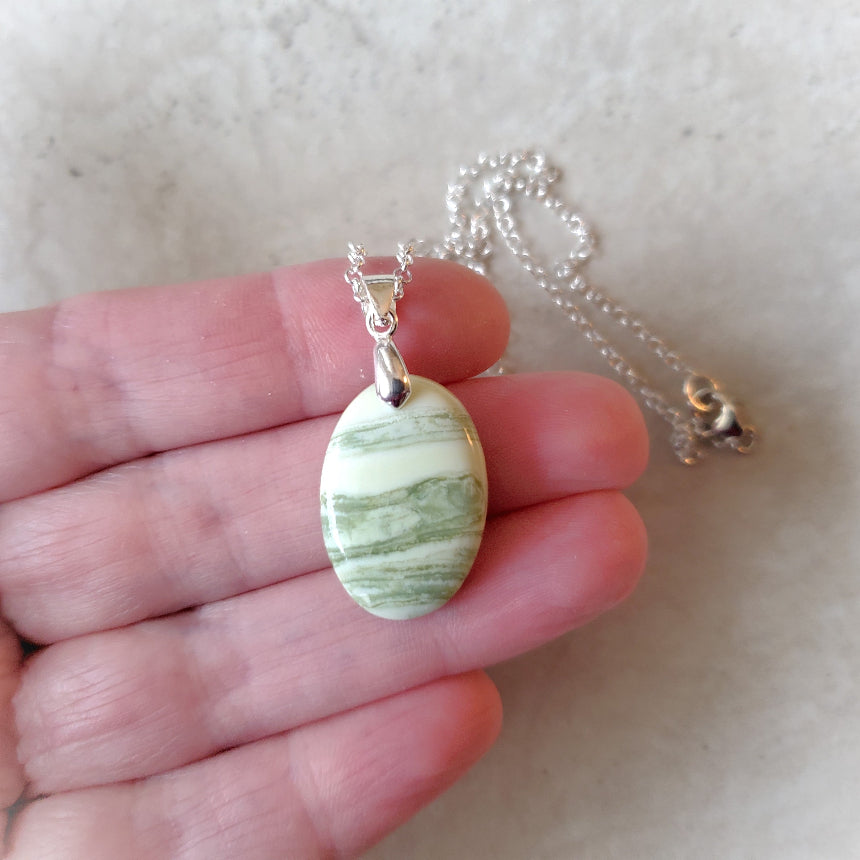Serpentine oval pendant necklace in hand