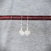 Moonstone heart earrings hanging on a branch