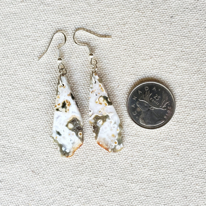 Freeform nugget Ocean Jasper earrings beside a quarter