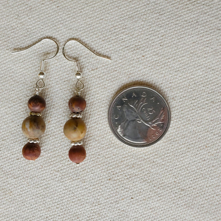 Picasso Jasper and crazy Lace Agate earrings beside a quarter